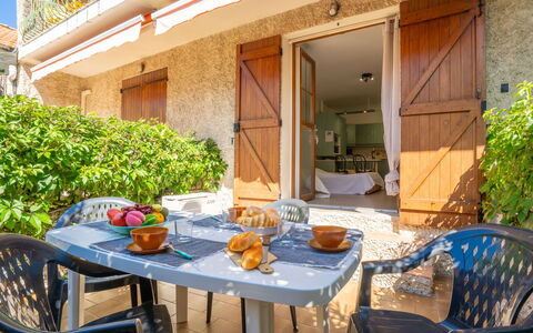 Le Lido: Bord, Møbel, Plante, Ejendom, Bygning, Stol, Blomsterkrukke, Vindue, Udendørs Bord, Skygge